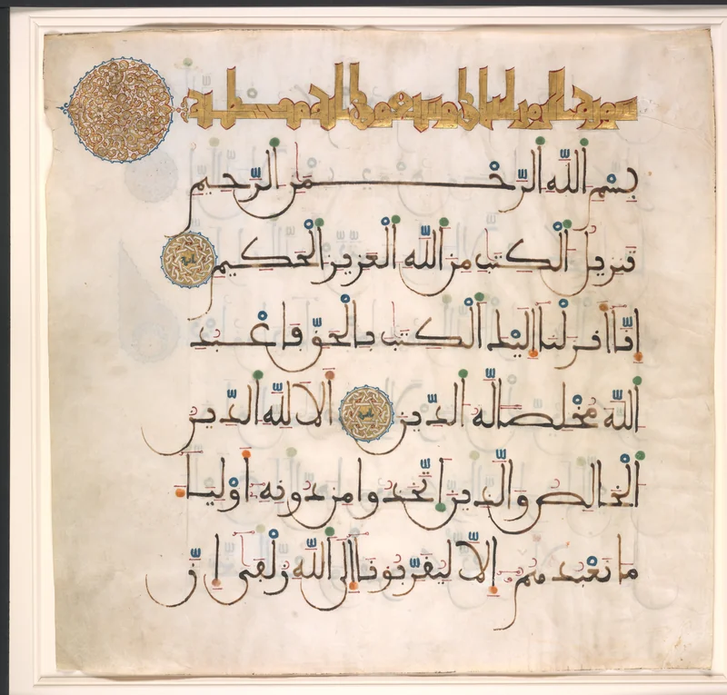 Maghribi Quran writing with deep rounded bowls, coloured dots and a gold Kufic heading.
