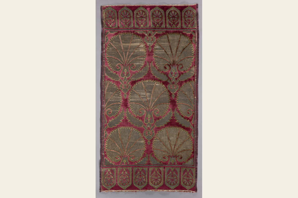 A tall Ottoman velvet cushion cover with rows of large carnations and small arched forms at the ends.