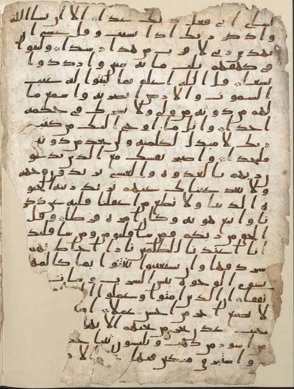 A parchment page of the Birmingham Quran with dark Hijazi writing and tall sloping strokes.